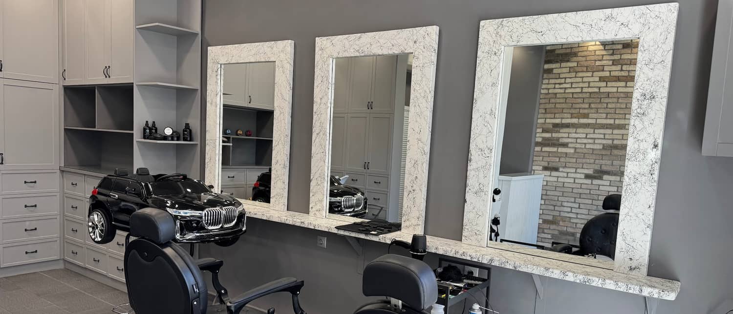 Οι τρεις καθρέφτες του GOSSHEEP BARBERSHOP πάνω από τον μαρμάρινο πάγκο, με το αυτοκινητάκι BMW και τις καρέκλες